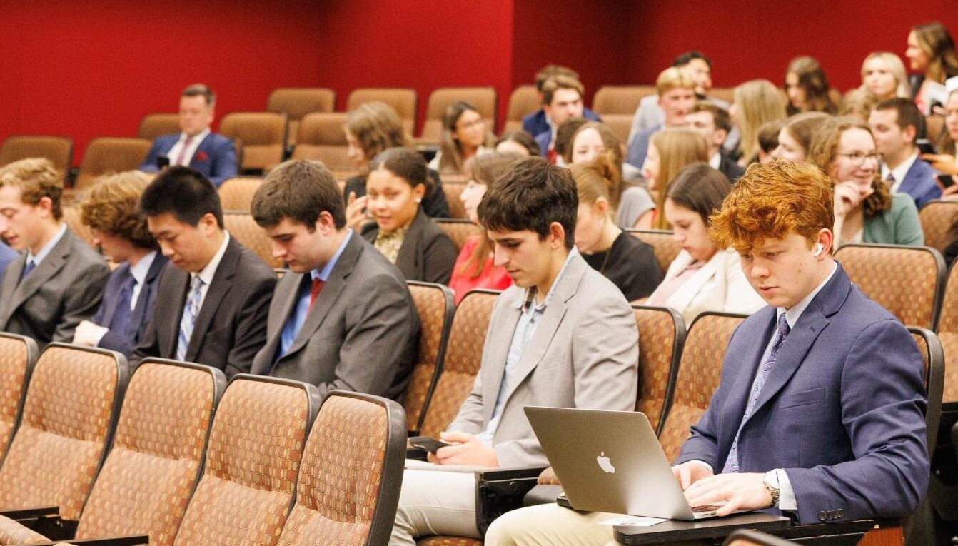 Students sit in a lecture hall.