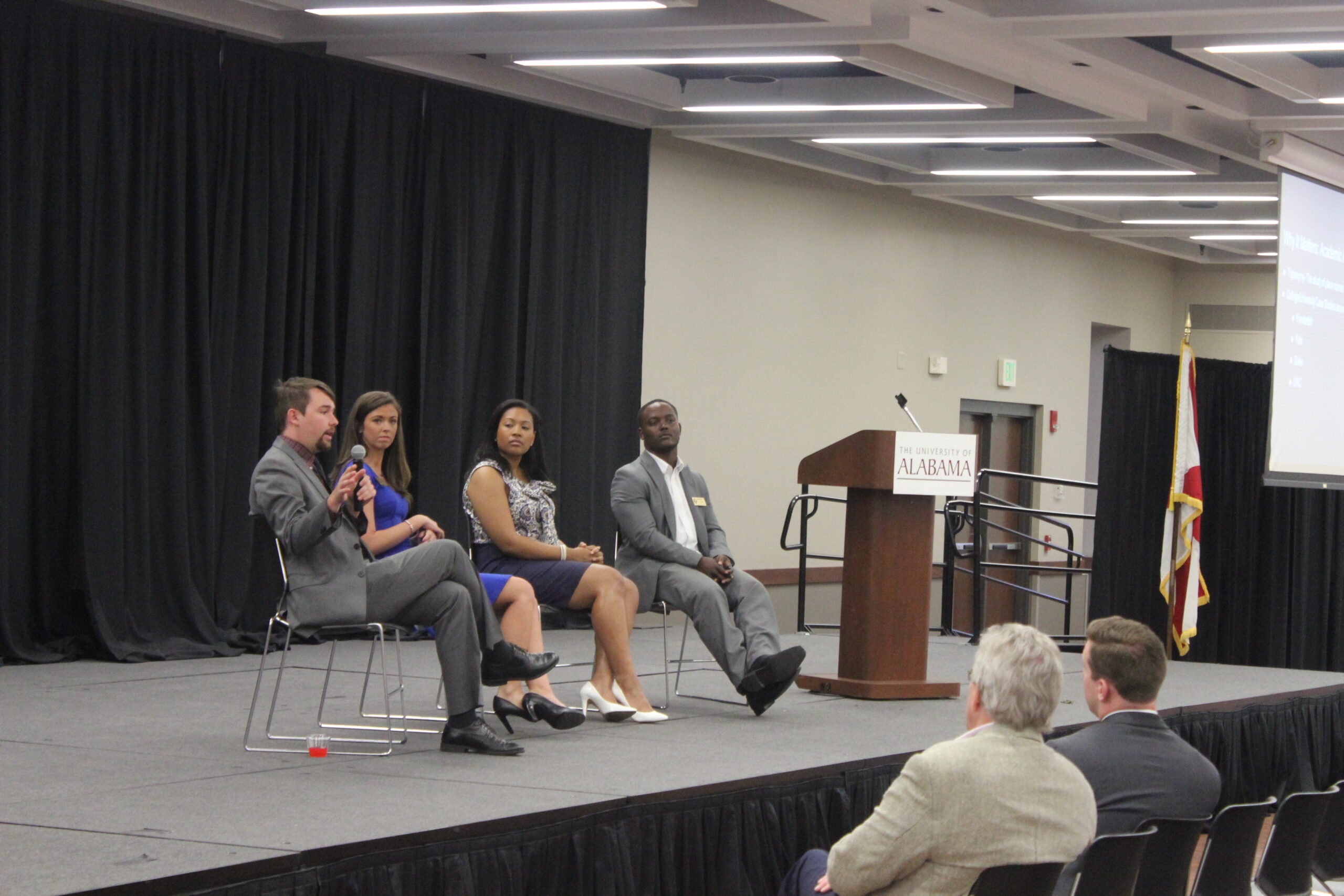 Four Witt Fellows are on a stage.