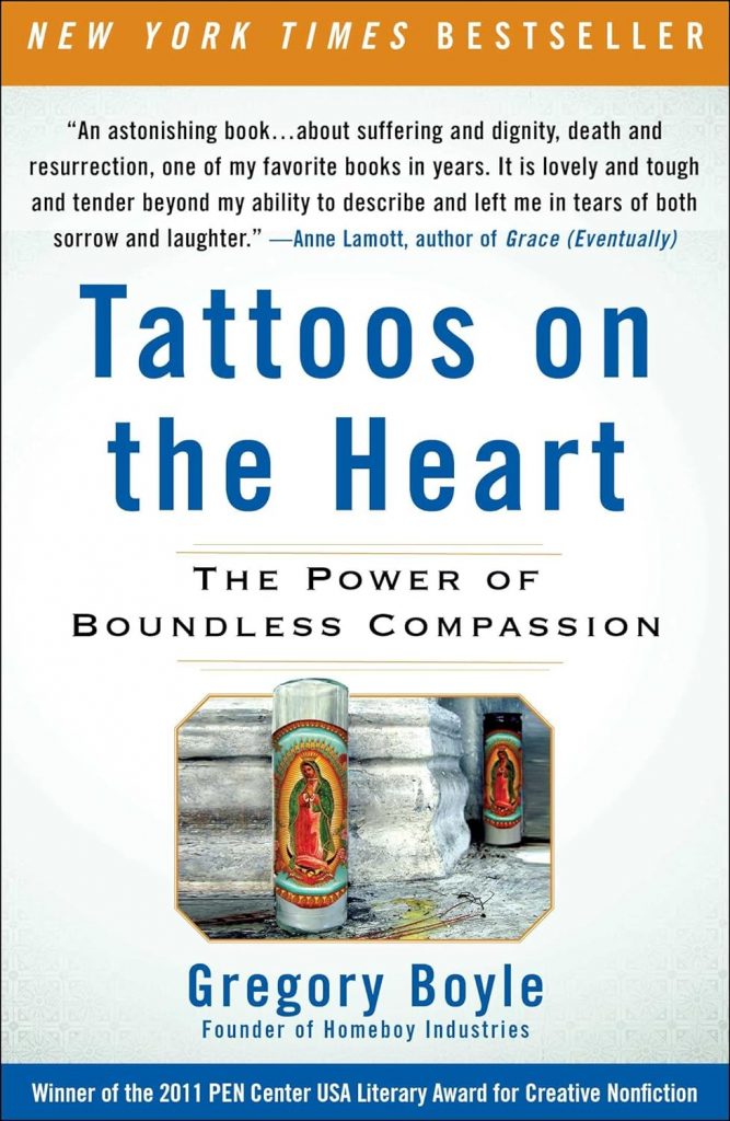 The book cover for "Tattoos on the Heart." It reads, "New York Times bestseller. "An astonishing book... about suffering and dignity, death and resurrection, one of my favorite books in years. It is lovely and tough and tender beyond my ability to describe and left me in tears of both sorrow and laughter." - Anne Lamott, author of "Grace (Eventually). Tattoos on the Heart. The Power of Boundless Compassion. Gregory Boyle Founder of Homeboy Industries. Winner of the 2011 PEN Center USA Literary Award for Creative Nonfiction." There is a photo of two prayer candles on the cover.
