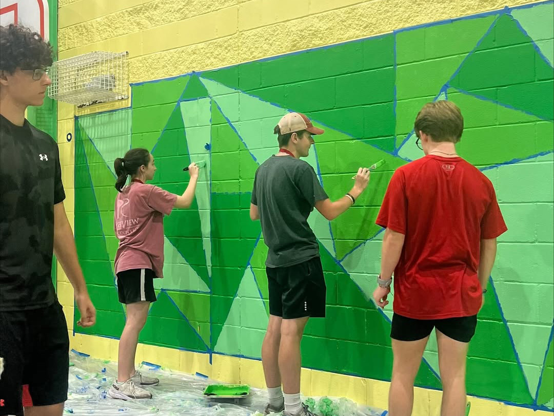 Students painting a wall.